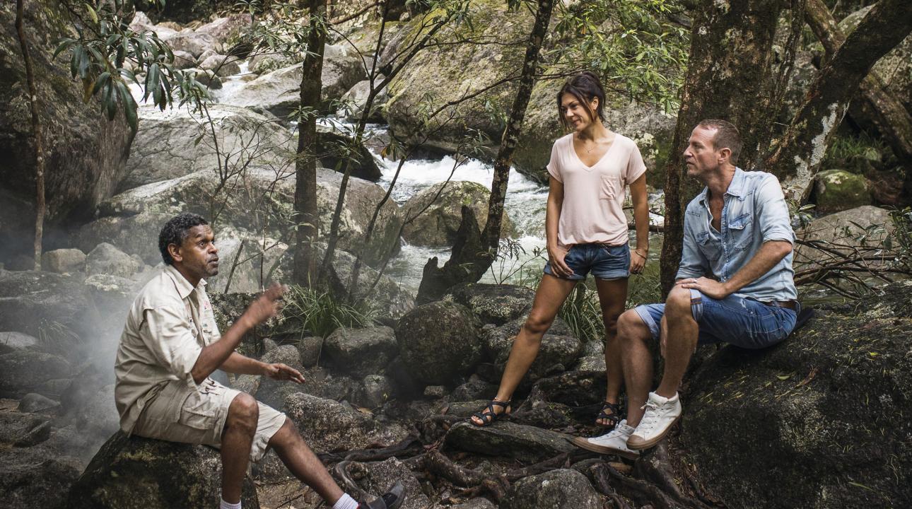 Indigenous guide guiding a couple through the woods