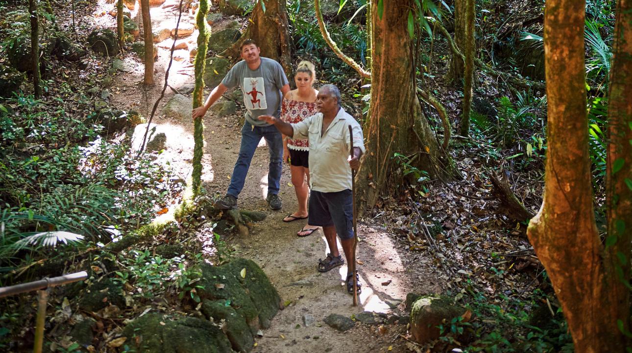 Indigenous guide guiding a couple through the woods