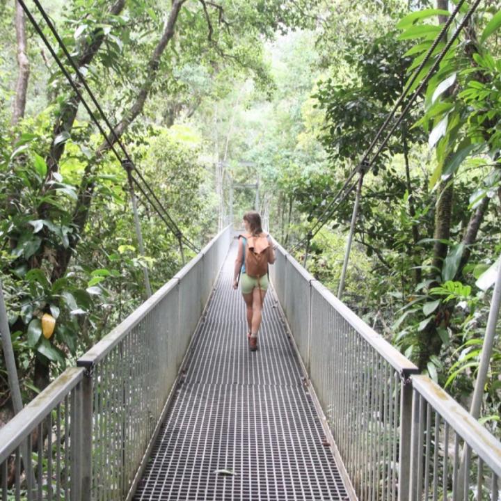 Woman walking across a suspension bridge 