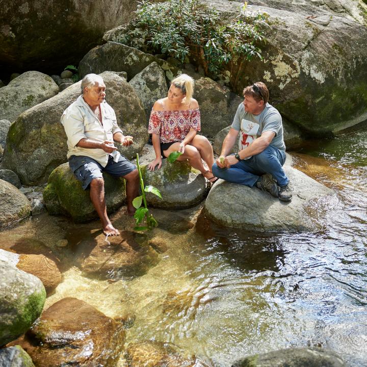 Couple sitting on rocks with a guide