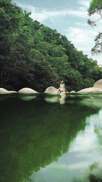 couple sitting on the rocks by a river