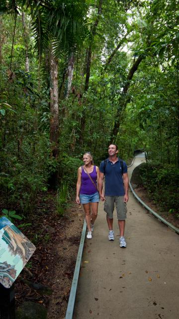 Couple walking down a path surrounded by trees