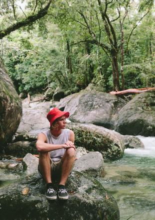 Man sitting on a rock in the middle of a river